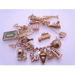 9CT GOLD CHARM BRACELET with padlock clasp and 25 charms, 68.5grms gross, charms include 'Owl and