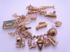 9CT GOLD CHARM BRACELET with padlock clasp and 25 charms, 68.5grms gross, charms include 'Owl and