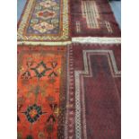 FOUR PERSIAN/MIDDLE EASTERN WOOLLEN CARPETS, three various tonal red ground with multi-bordered