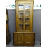 ANTIQUE SCUMBLED PINE TWO PIECE CORNER CUPBOARD having a shaped cornice over twin four panel