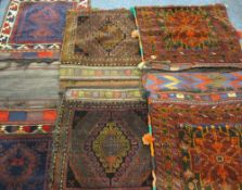 THREE MIDDLE EASTERN/PERSIAN TYPE CARPET CAMEL BAGS in mixed colours, in traditional bordered