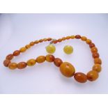 GRADUATED AMBER TYPE BEAD NECKLACE and a non-matching pair of earrings, 40cms L the necklace,