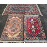 THREE MIDDLE EASTERN TYPE WOOLLEN CARPETS, mixed blue, red and cream ground with similarly styled