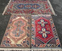 THREE MIDDLE EASTERN TYPE WOOLLEN CARPETS, mixed blue, red and cream ground with similarly styled