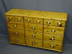 REPRODUCTION PINE CHEST of twelve drawers with brass effect cup handles, 75cms H, 119cms W, 35.