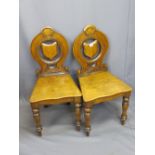 VICTORIAN OAK HALL CHAIRS, A PAIR, the circular backs with carved detail, central pierced shield