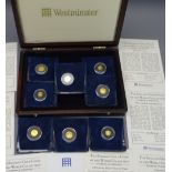 EIGHT WESTMINSTER 'SMALLEST GOLD COINS OF THE WORLD COLLECTION' in a mahogany effect case with