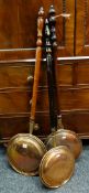 THREE VICTORIAN COPPER WARMING PANS with turned handles, all with foliate decorated covers,