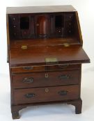 GEORGE II MAHOGANY BUREAU of small proportions, moulded rectangular fall with engraved escutcheon,