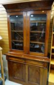 LATE VICTORIAN WALNUT BOOKCASE, angled cornice, glazed upper section doors, cushion frieze drawers