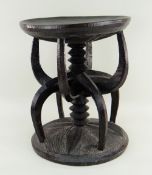 NRI-AWKA PRESTIGE STOOL, with carved spindle and claw column support, 34.5cms diam. Condition
