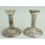 PAIR OF FILLED SILVER DWARF CANDLESTICKS of circular shape featuring bird and scroll repousse