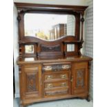 EDWARDIAN WALNUT PARLOUR CABINET with mirror glazed and carved back, above chest base of cupboards