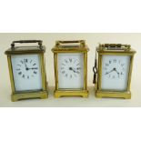 THREE SIMILAR BRASS CARRIAGE CLOCKS all with swing handles and enamel faces one being a presentation