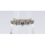 18CT GOLD & PLATINUM DIAMOND RING, the three central diamonds flanked by diamond chip shoulders,