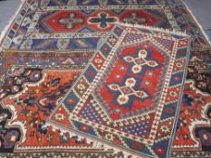 THREE EASTERN STYLE WOOL CARPETS, red and blue grounds with traditional patterns to a central