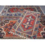 THREE EASTERN STYLE WOOL CARPETS, red and blue grounds with traditional patterns to a central