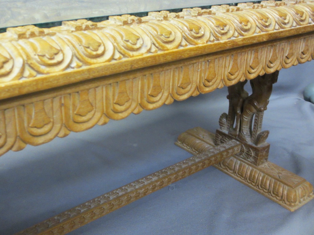 AN EASTERN HEAVILY CARVED LONG-JOHN COFFEE TABLE with a glazed top, 50cms H, 150cms W, 56cms D - Image 4 of 4