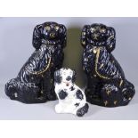 STAFFORDSHIRE JACKFIELD TYPE BLACK SEATED SPANIELS, a pair, 37cms H and one other