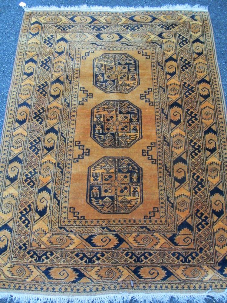 A MUSTARD COLOURED WOOLLEN RUG with tasselled ends, 200 x 143cms
