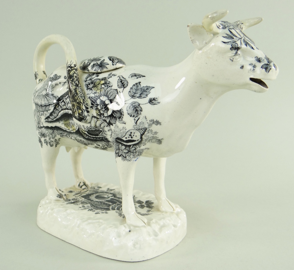 A GLAMORGAN POTTERY COW CREAMER with tail as loop handle, standing on a naturalistic oval base,
