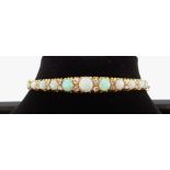 15CT GOLD OPAL & DIAMOND BANGLE, the eleven graduating opals alternating with graduating pairs of