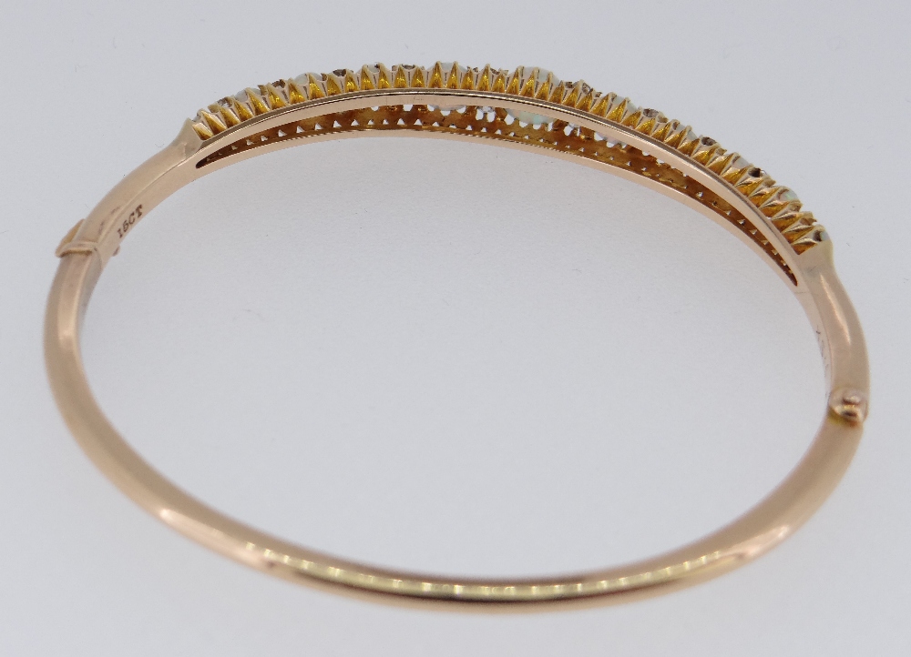 15CT GOLD OPAL & DIAMOND BANGLE, the eleven graduating opals alternating with graduating pairs of - Image 5 of 6