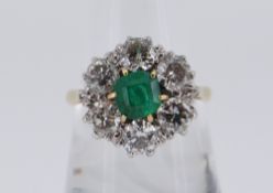18CT GOLD EMERALD & DIAMOND CLUSTER RING, the central emerald (0.5 x 0.5cms) surrounded by six