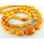 STRING OF AMBER BUTTERSCOTCH BEADS the oval graduated beads measuring 1.3cms long (smallest) to 3cms