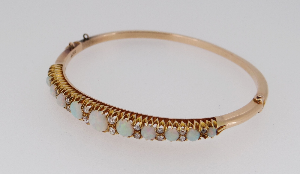 15CT GOLD OPAL & DIAMOND BANGLE, the eleven graduating opals alternating with graduating pairs of - Image 4 of 6