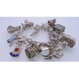 SILVER CHARM BRACELET with padlock clasp and 15 various charms including a £1 note in emergency