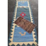 TWO EASTERN STYLE WOOLLEN CARPETS to include a small scatter rug with traditional pattern on brown