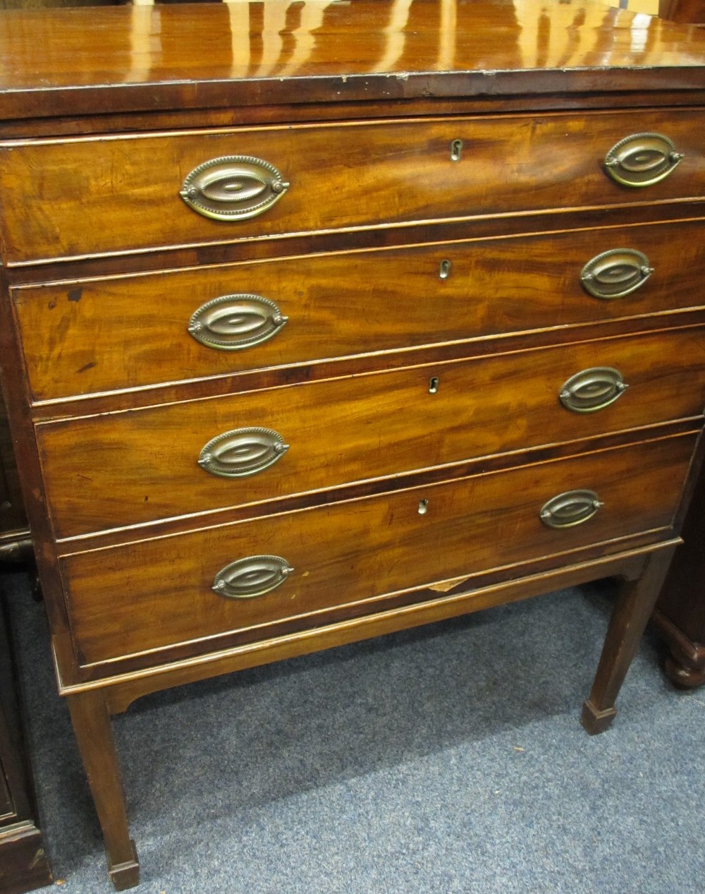 REGENCY MAHOGANY FOUR DRAWER CHEST on corner tapering supports with spade feet, the oak lined