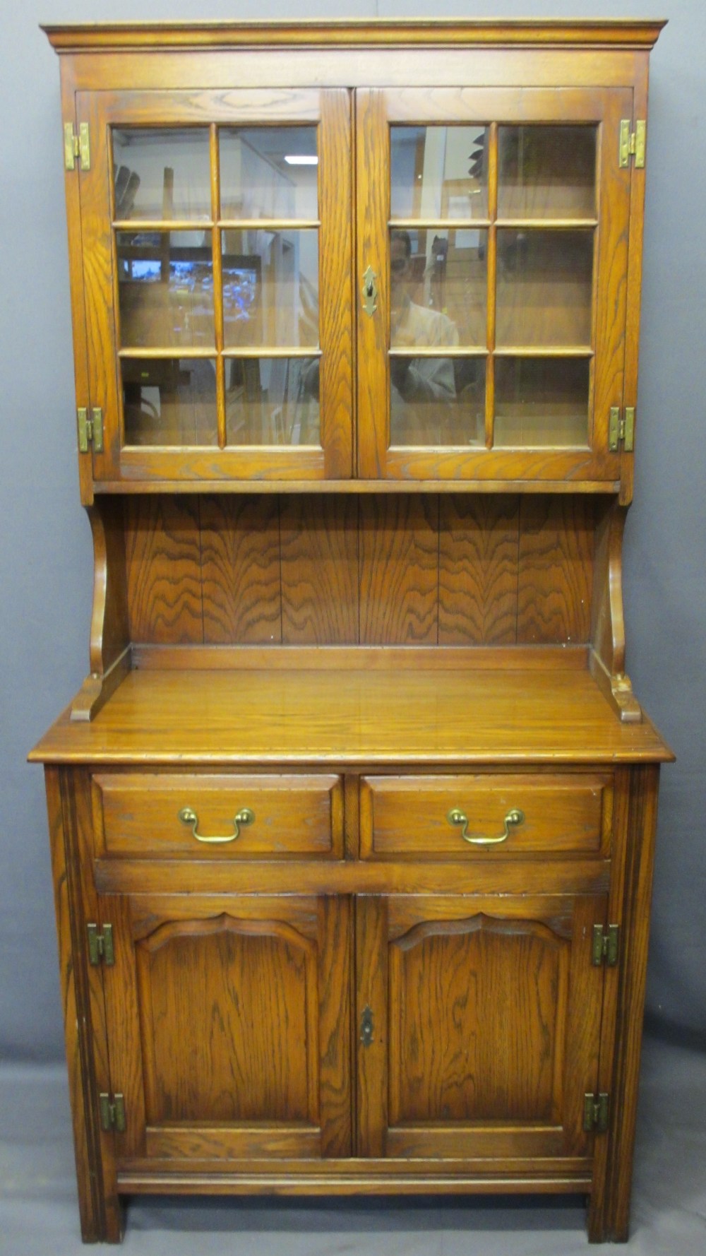 REPRODUCTION OAK GLASS TOP DRESSER having twin six pane glazed doors with interior shelves and brass