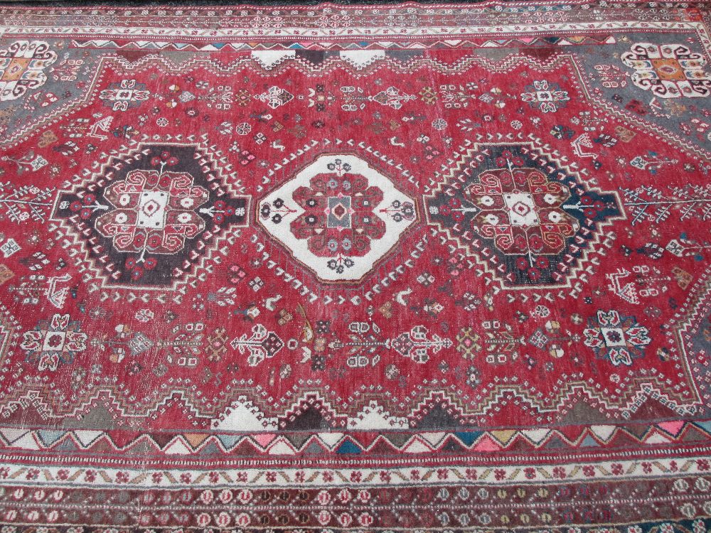 EASTERN WOOLLEN CARPET red ground with traditional central block pattern and multi-bordered