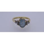 AN 18CT GOLD DRESS RING with a cluster of oval blue quartz and three tiny flanking diamonds either