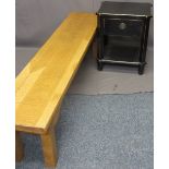 MODERN LONG OAK BENCH and a reproduction ebonized single drawer bedside table, 45cms H, 179.5cms