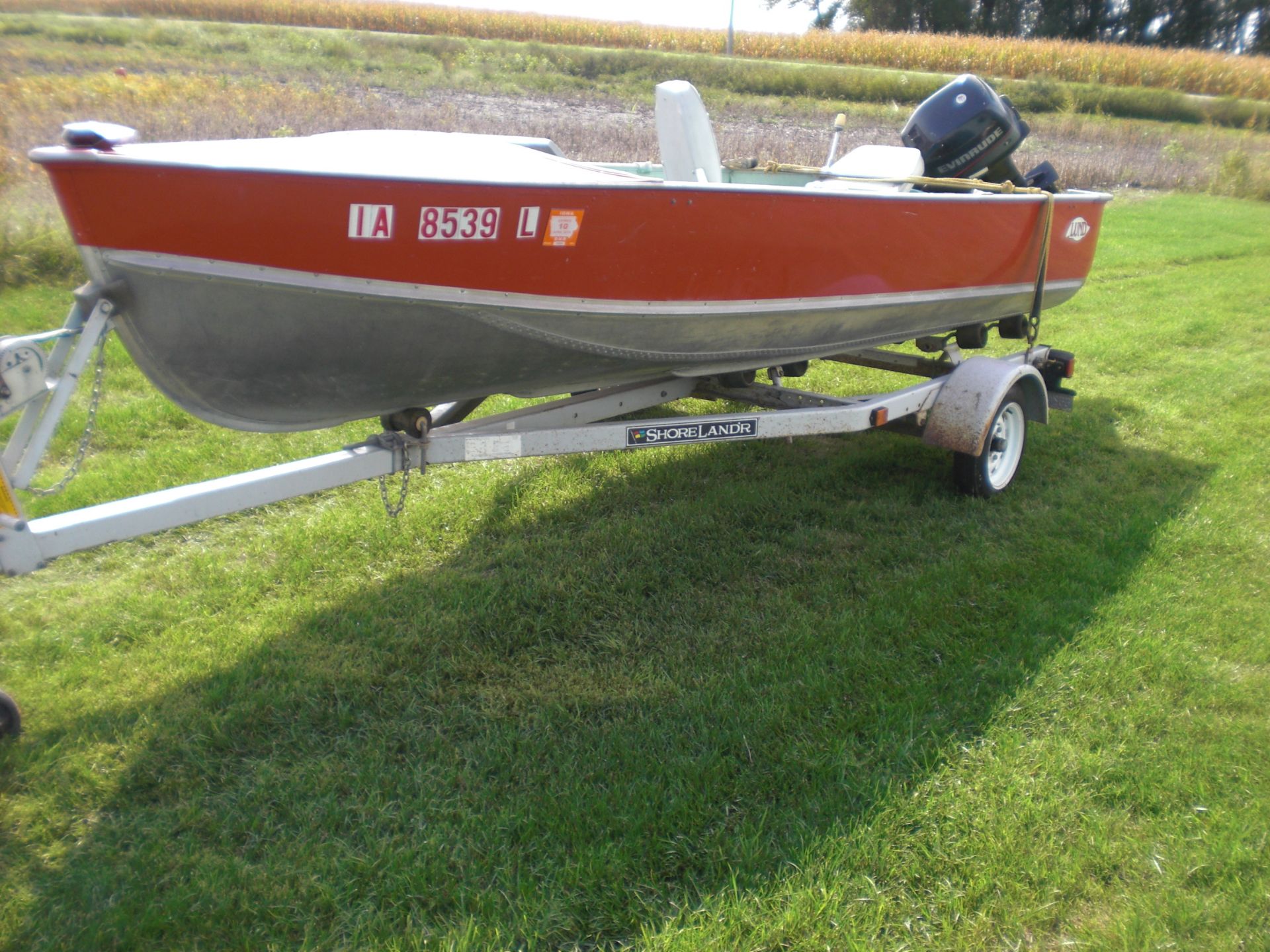 16’ Lund boat w/25 HP 2 cycle oil injected Evinrude motor on Shore Lander trailer.