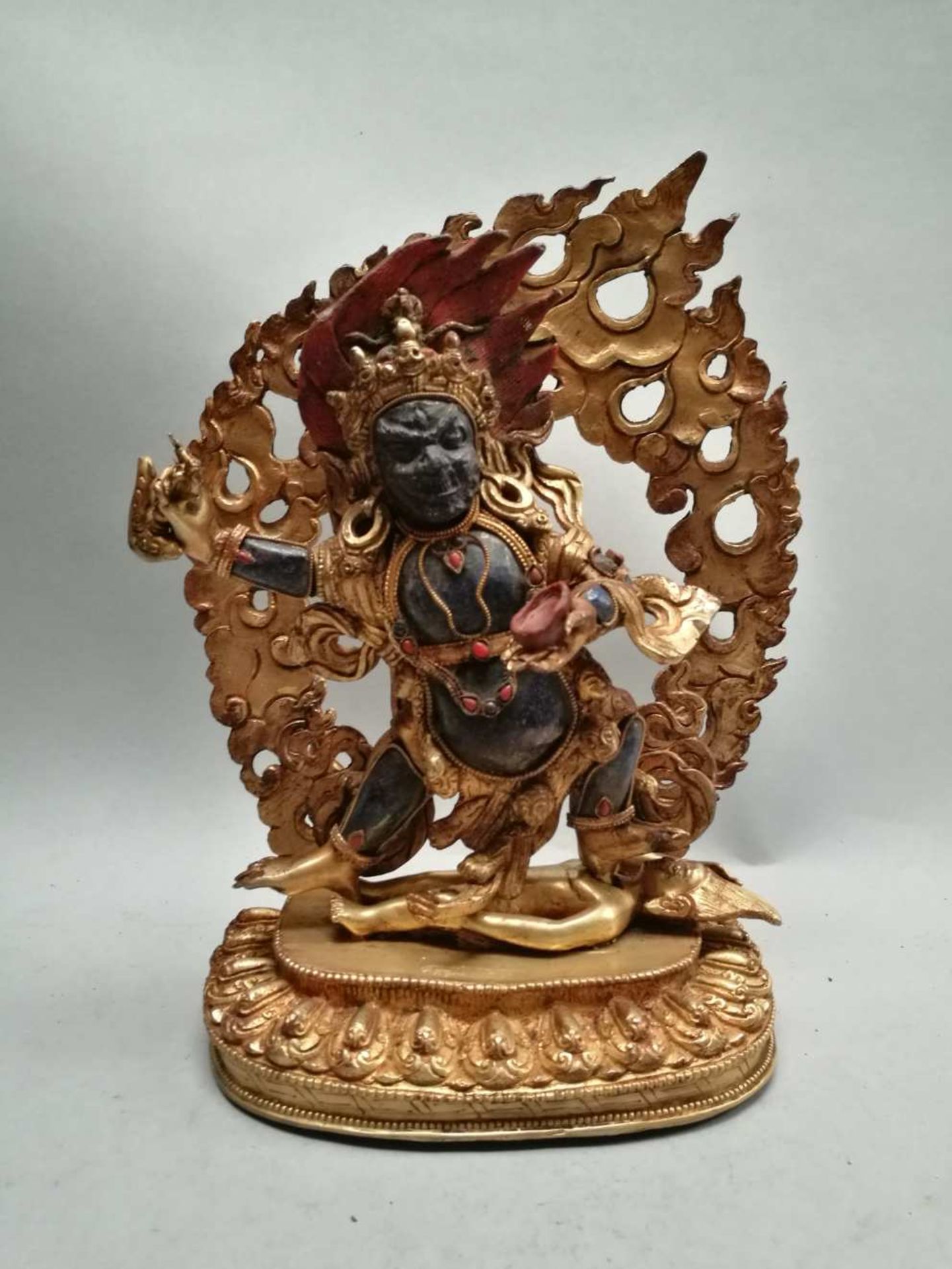 TIBET. Mahakala dans une mandorle reposant sur une base lotiforme où figure un personnage allongé,