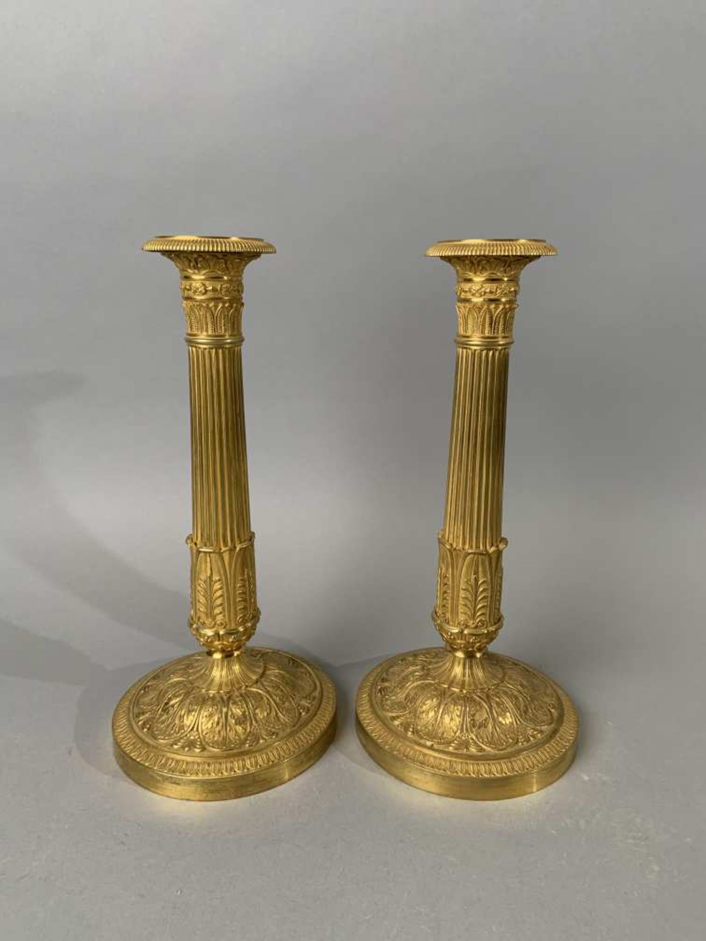 Paire de flambeaux en bronze doré et ciselé à décor de palmettes. Epoque Restauration. H. 28 cm.