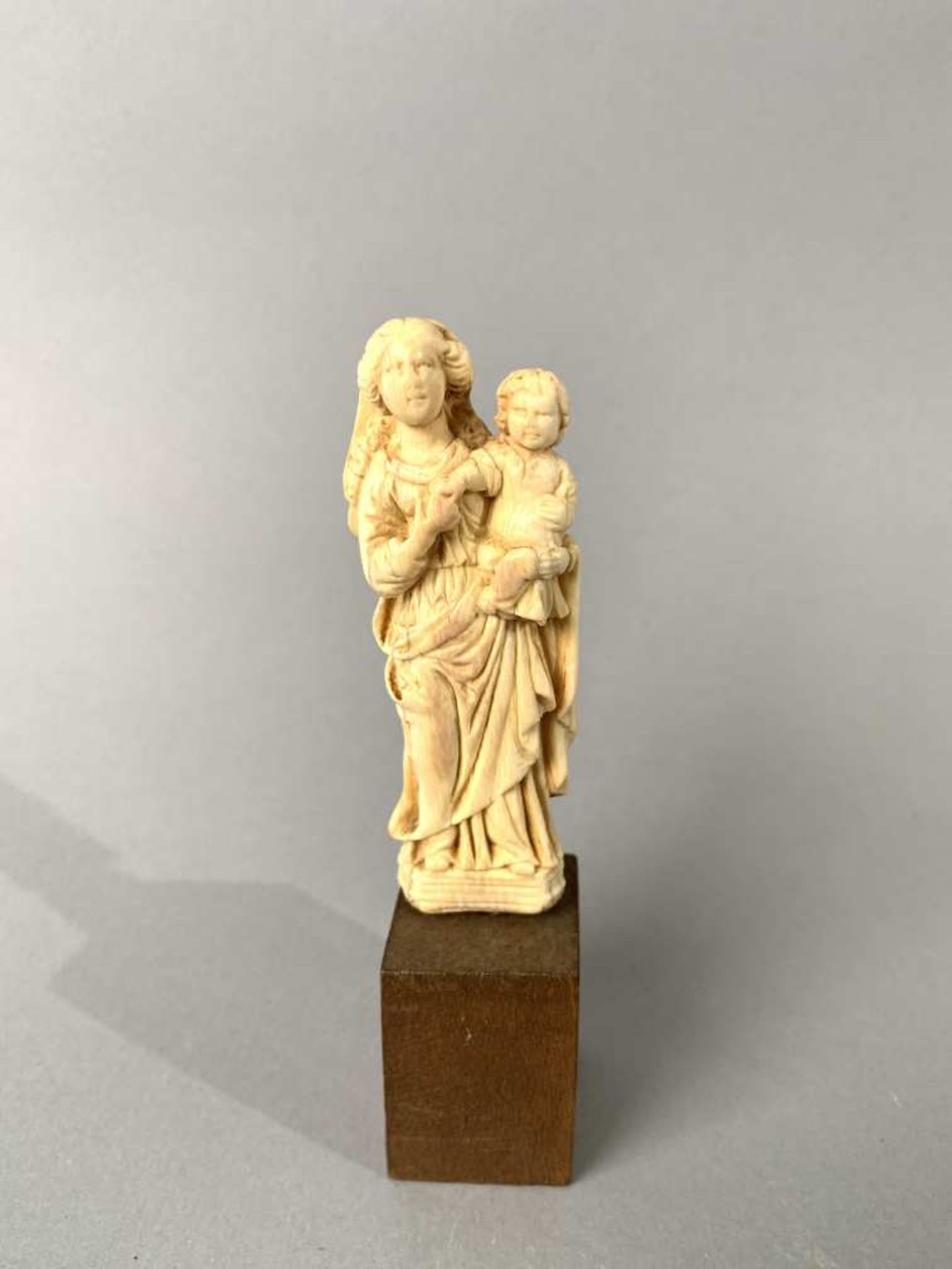 Vierge à l'Enfant en ivoire sculpté en ronde-bosse. Debout, Marie porte l'Enfant sur son bras gauche