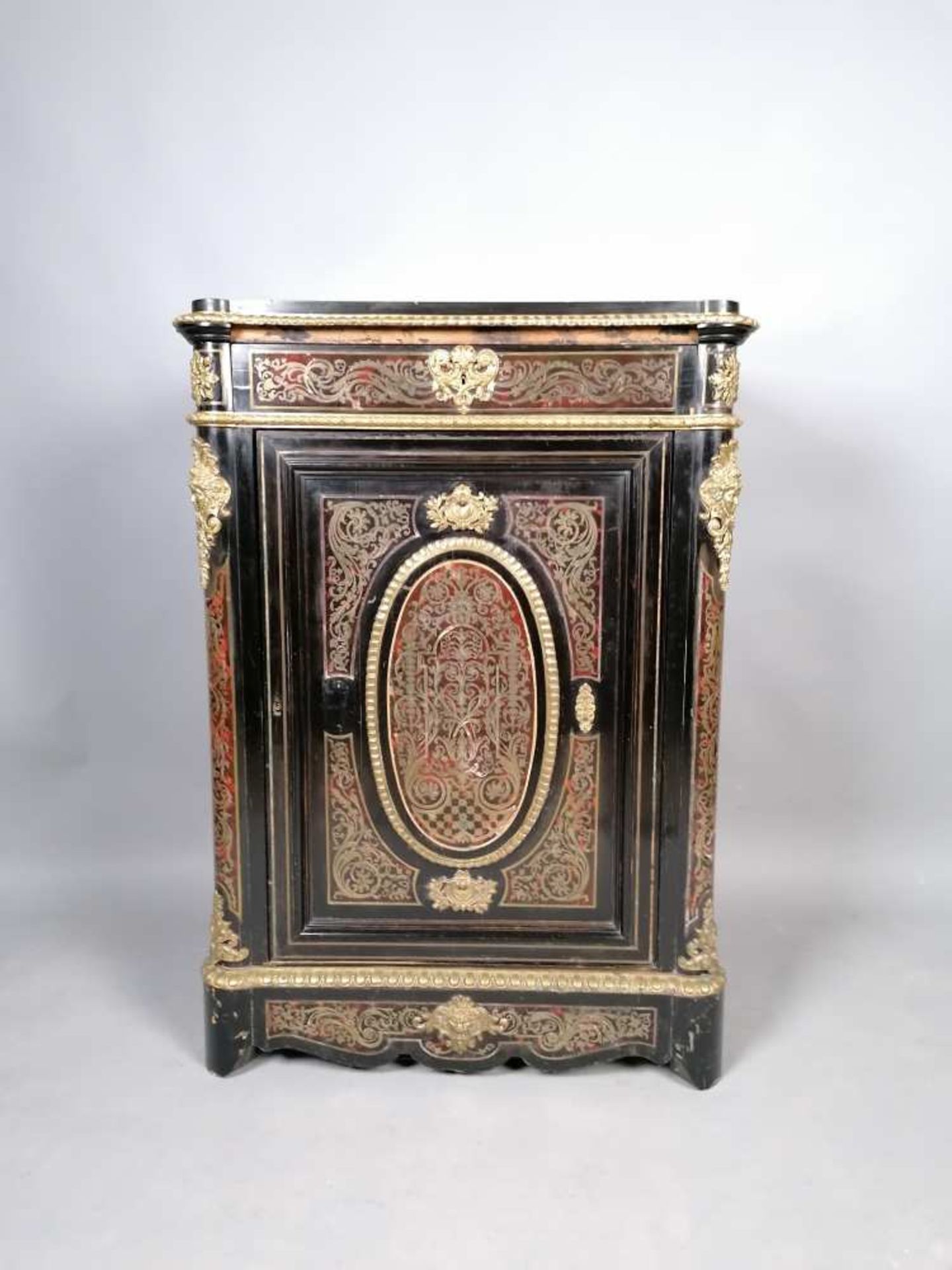 Meuble à hauteur d'appui ouvrant par une porte, en bois noirci à marqueterie de type Boulle en