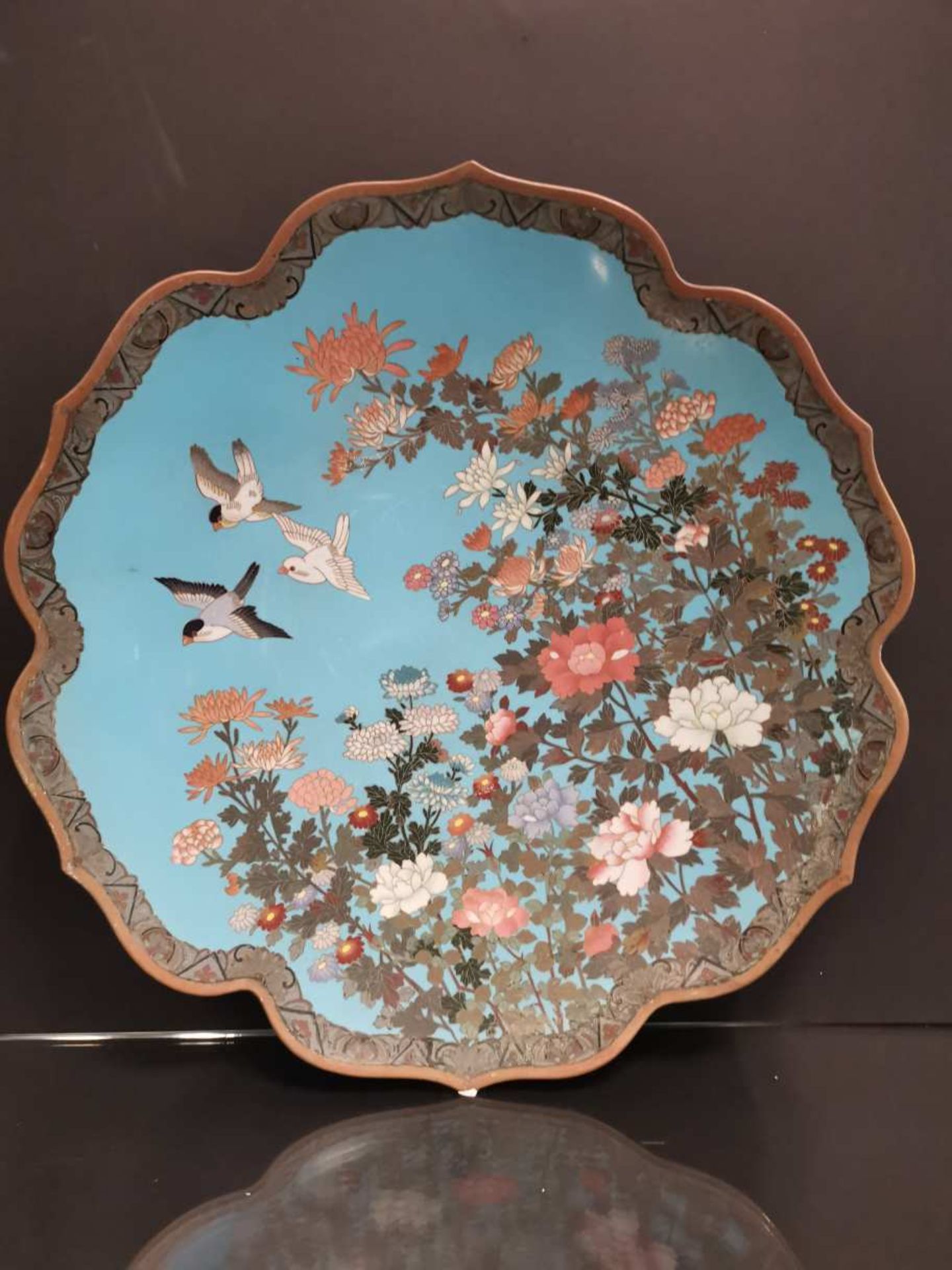 JAPON. Grand plat à décor en cloisonné d'oiseaux et d'arbres en fleurs sur fond bleu et d'une