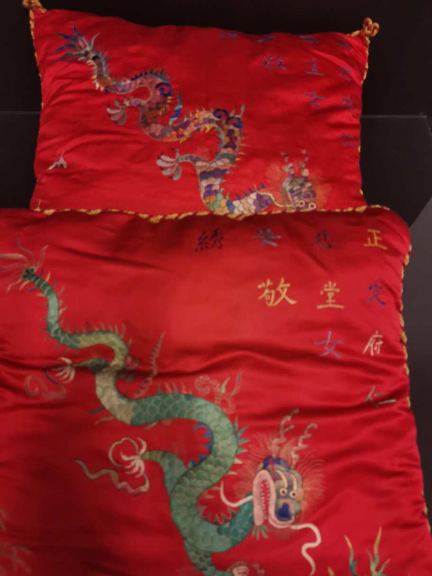 CHINE - VIETNAM. Deux coussins en soie brodée à décor de dragons, idéogrammes.