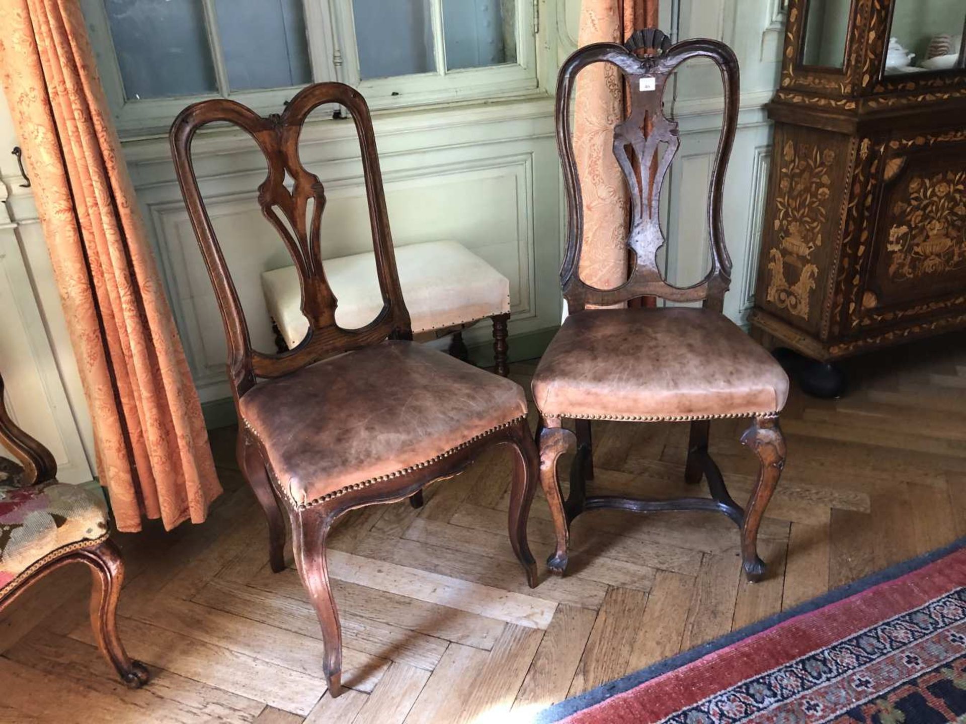 Fausse paire de chaises en bois naturel sculpté à dossier ajouré. Assise en cuir. Restauration.