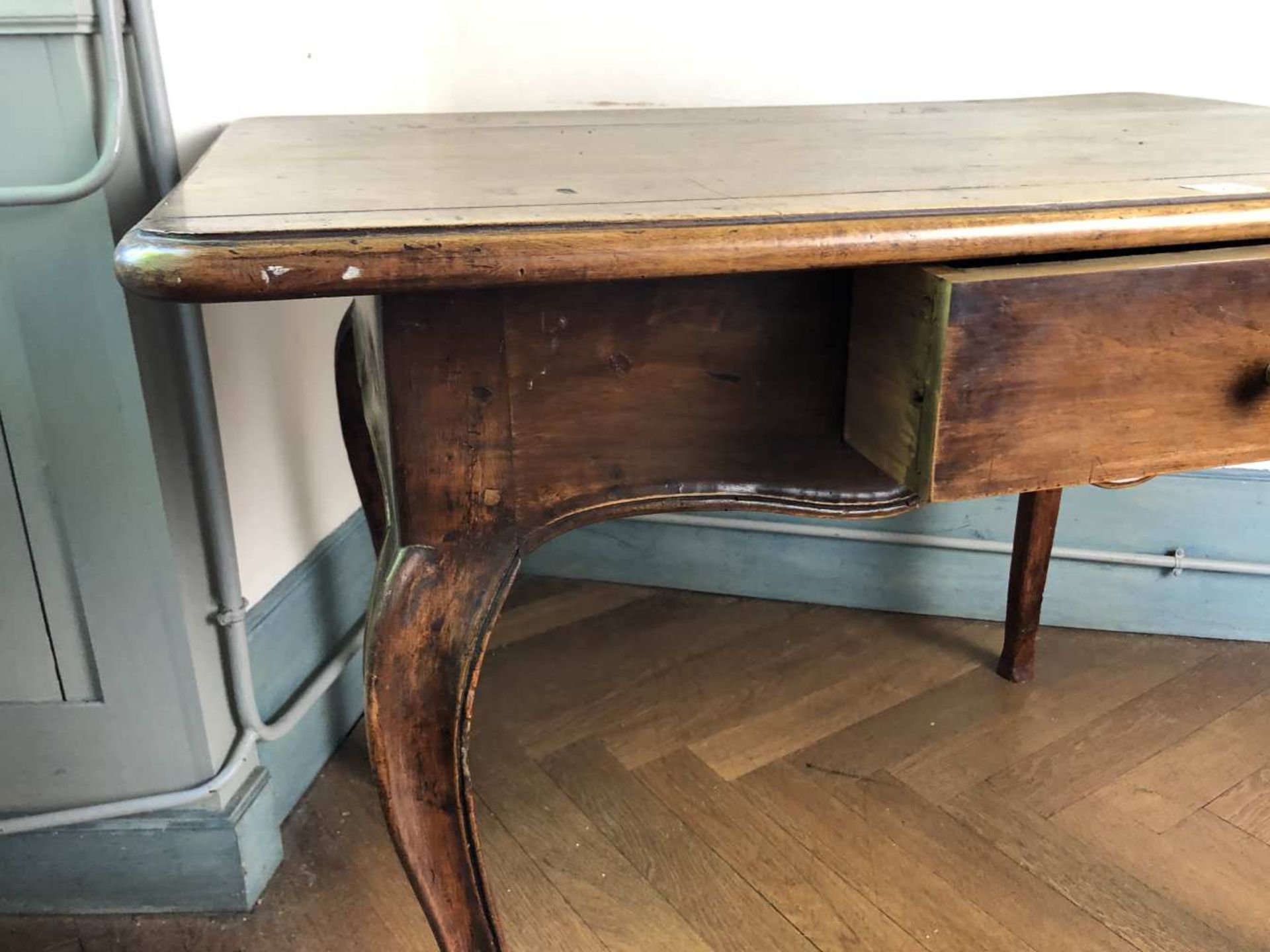 Table à écrire Louis XV en noyer ouvrant par un tiroir en ceinture, à plateau rapporté, reposant sur