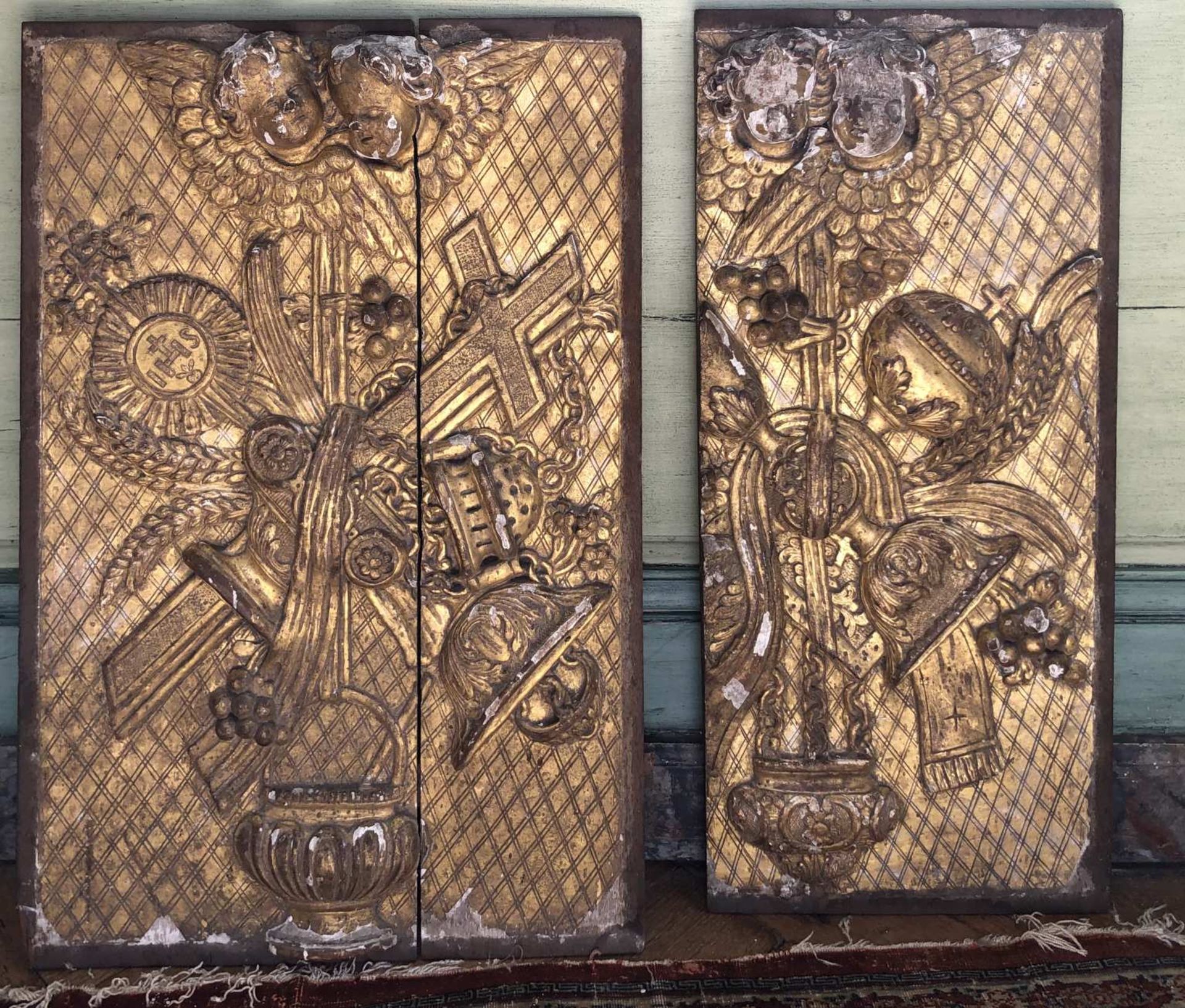 Deux éléments (de tabernacle) en bois doré à décor sculpté de motifs d'objets religieux et têtes d'