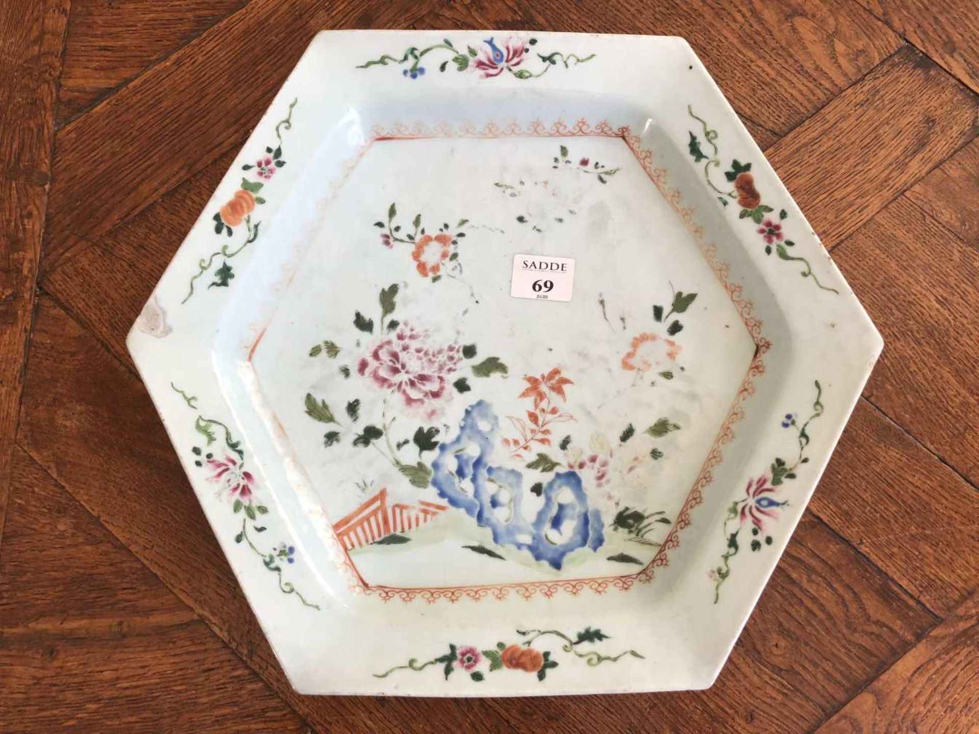 CHINE. Plat de forme hexagonale en porcelaine émaillée à décor d'un rocher fleuri. Usures au