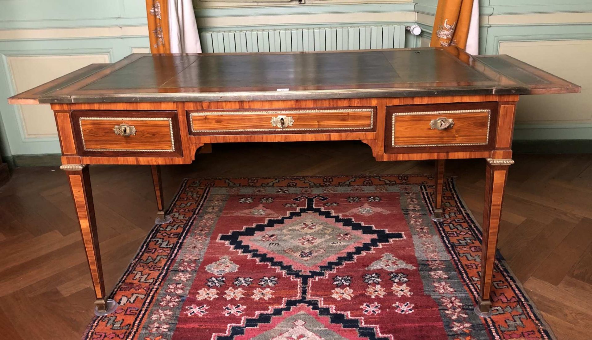 Bureau plat rectangulaire gainé de cuir, en placage de bois de rose et bois de violette ouvrant