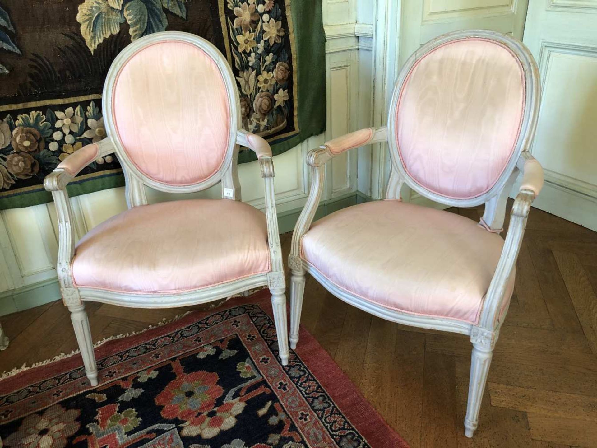 Paire de fauteuils à dossier médaillon en bois laqué gris, reposant sur quatre pieds ronds